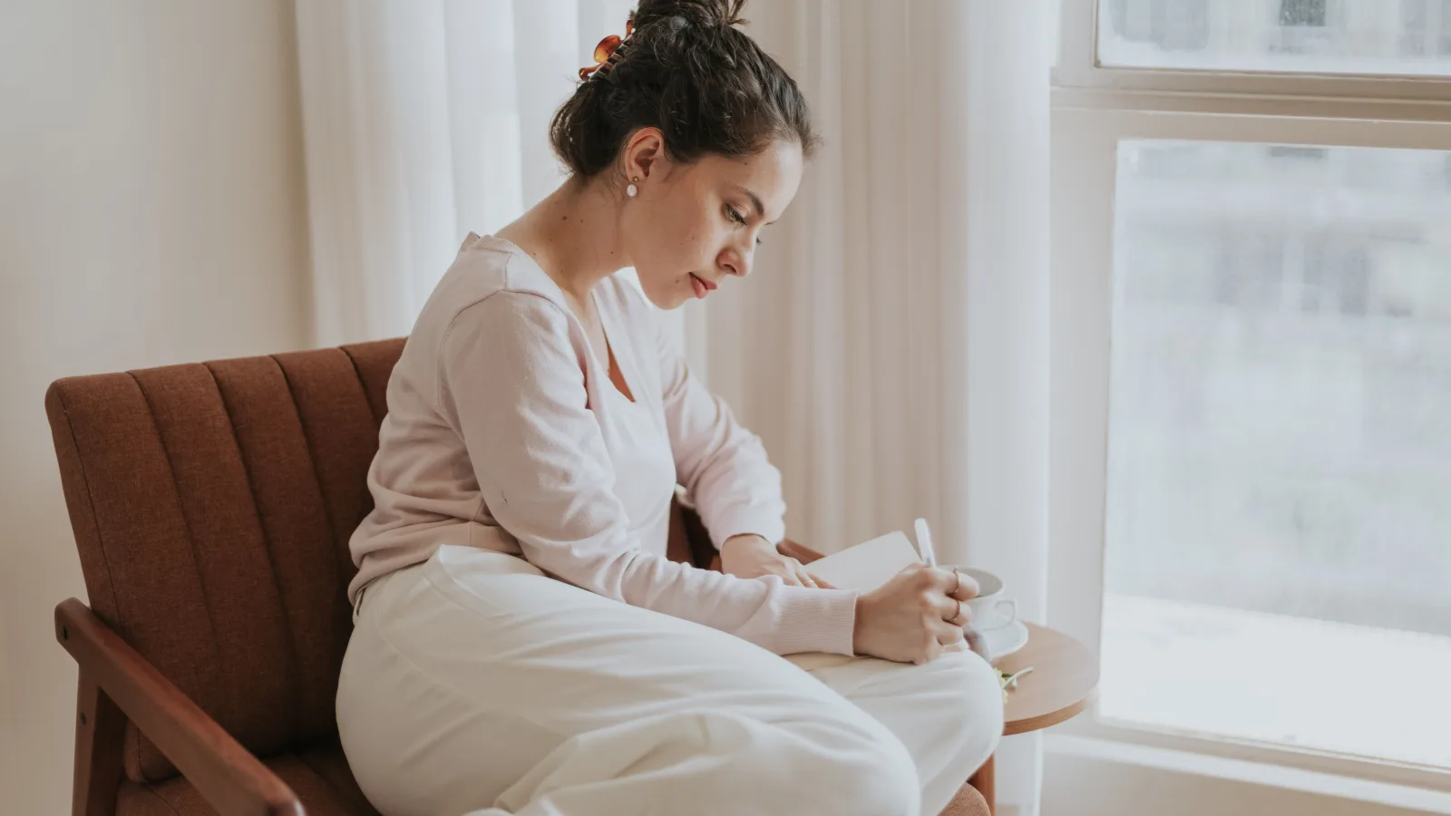 woman journaling window light